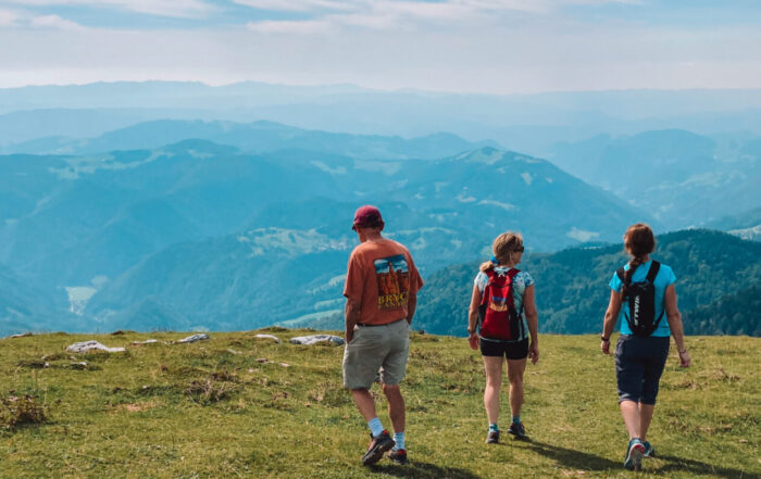 The three figures, walking side by side, seem to be in perfect harmony with the land — each step a reminder of the peaceful connection between adventure and nature.